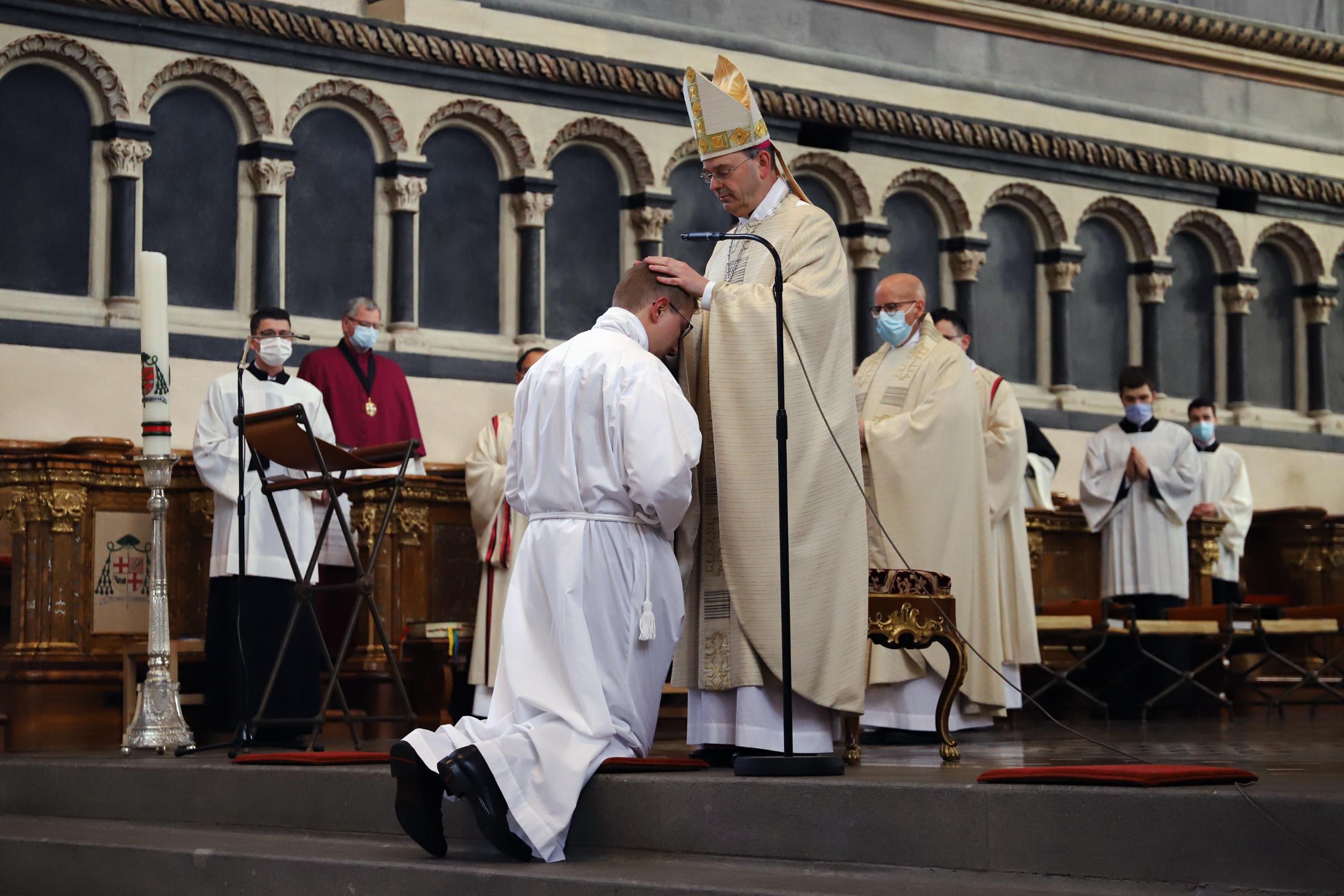 Durch Handauflegung wird Christian Kossmann von Weihbischof Robert Brahm zum Diakon geweiht.