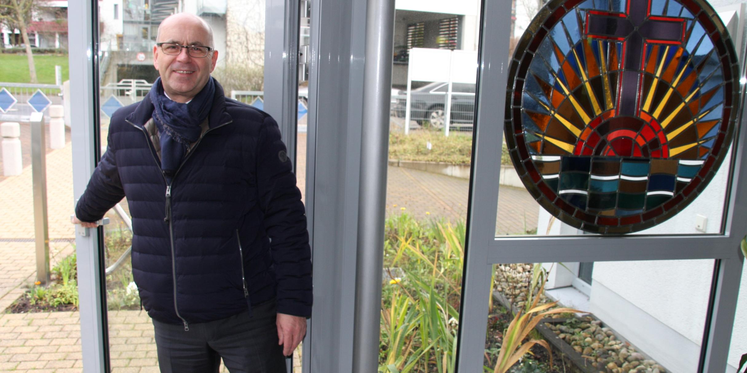Gemeindeleiter Roger Tech von der Neuapostolischen Kirche, Gemeinde Koblenz, öffnet die Tür für interessierte Gottesdienstbesucher