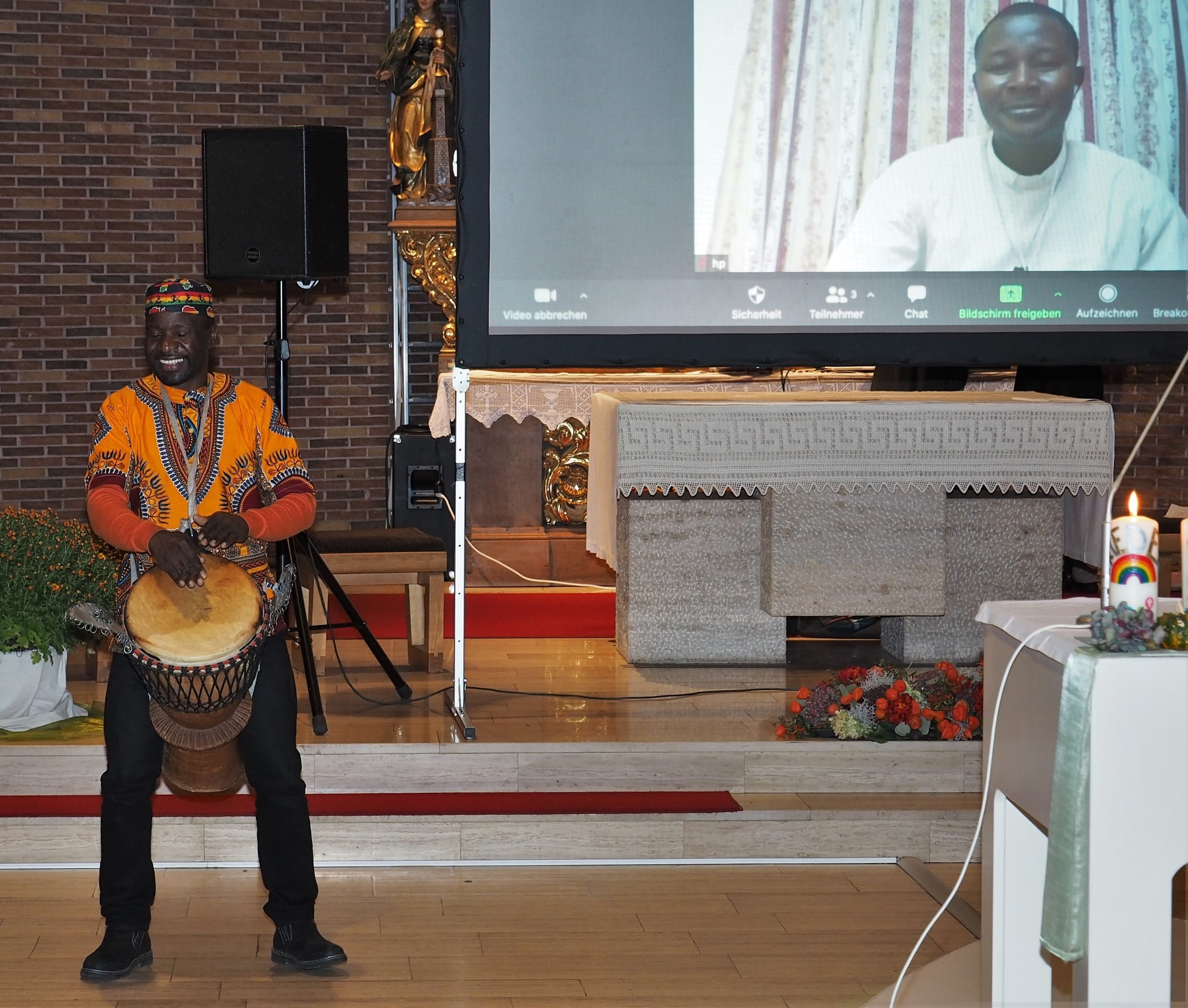 Den afrikanischen Klängen des Musikers Dédé Mazietele Vavi lauscht auch der per Video zugeschaltete Abbé Marcellin Ouedraogo. Foto: Stefan Endres
