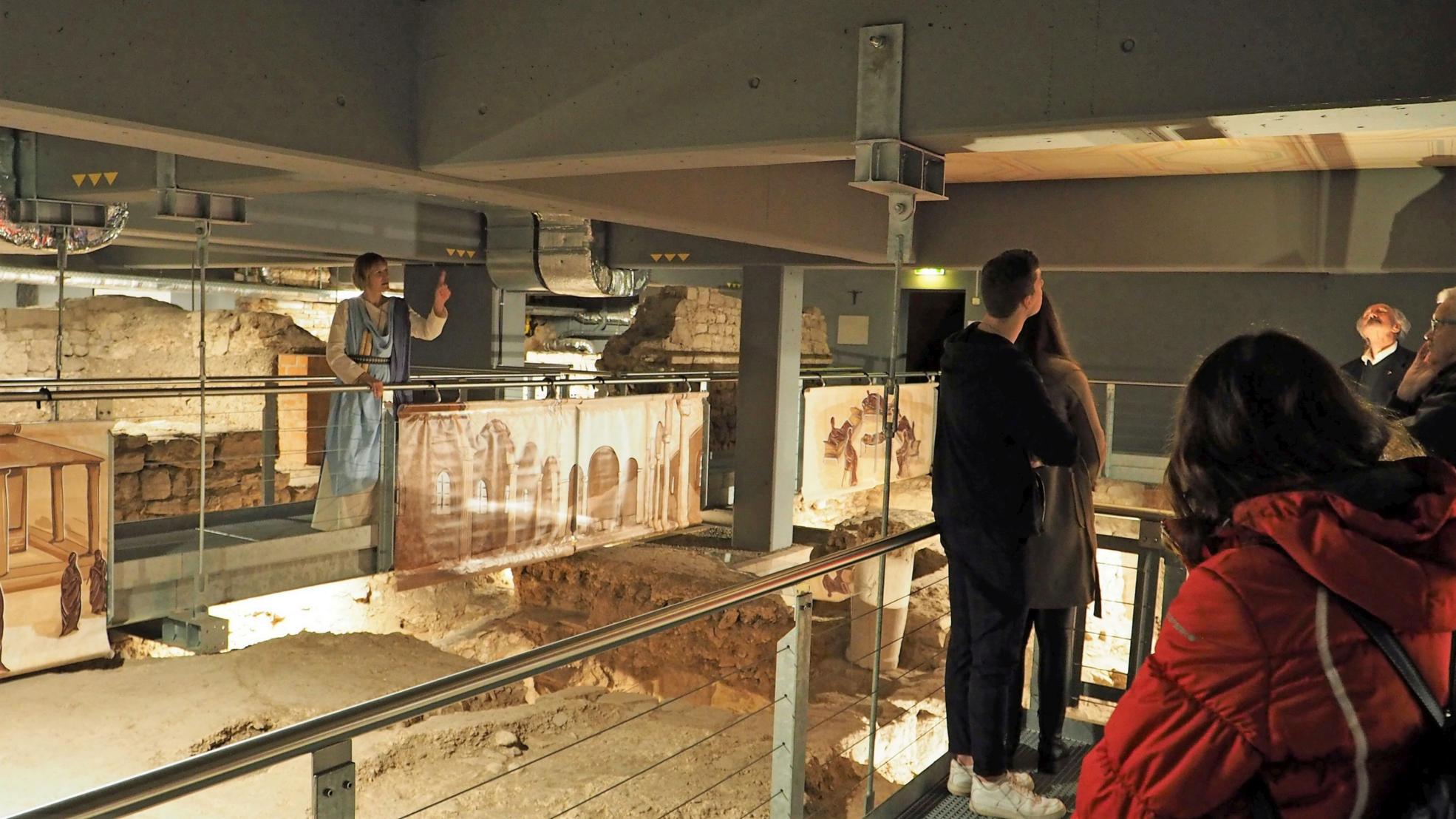 Aurelia (Dr. Paula Kolz, links) macht in der Ausgrabung auch auf antike, bemalte Deckenfragmente aufmerksam.