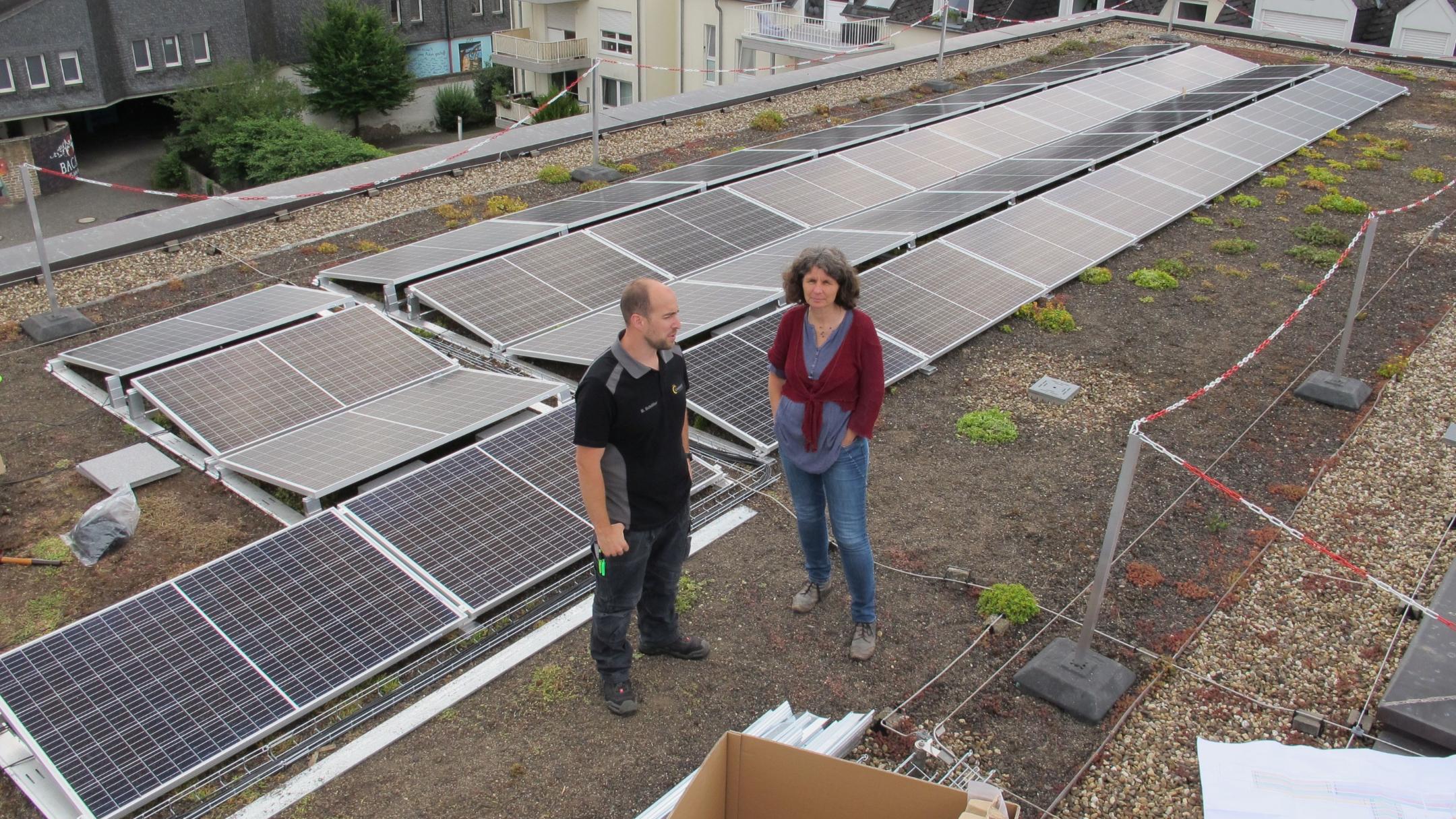 Bernd Schöller von der Firma SchoEnergie aus Föhren mit der Klimaschutzmanagerin Charlotte Kleinwächter auf dem Dach des Angela-Merici-Gymnasiums in Trier.