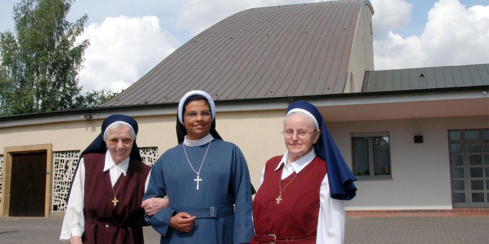 Die beiden Redemptoristinnen Schwester Pia (links) und Schwester Margret (rechts) mit Schwester Jaseentha, der Oberin der Nazarethschwestern vor der Klosterkirche