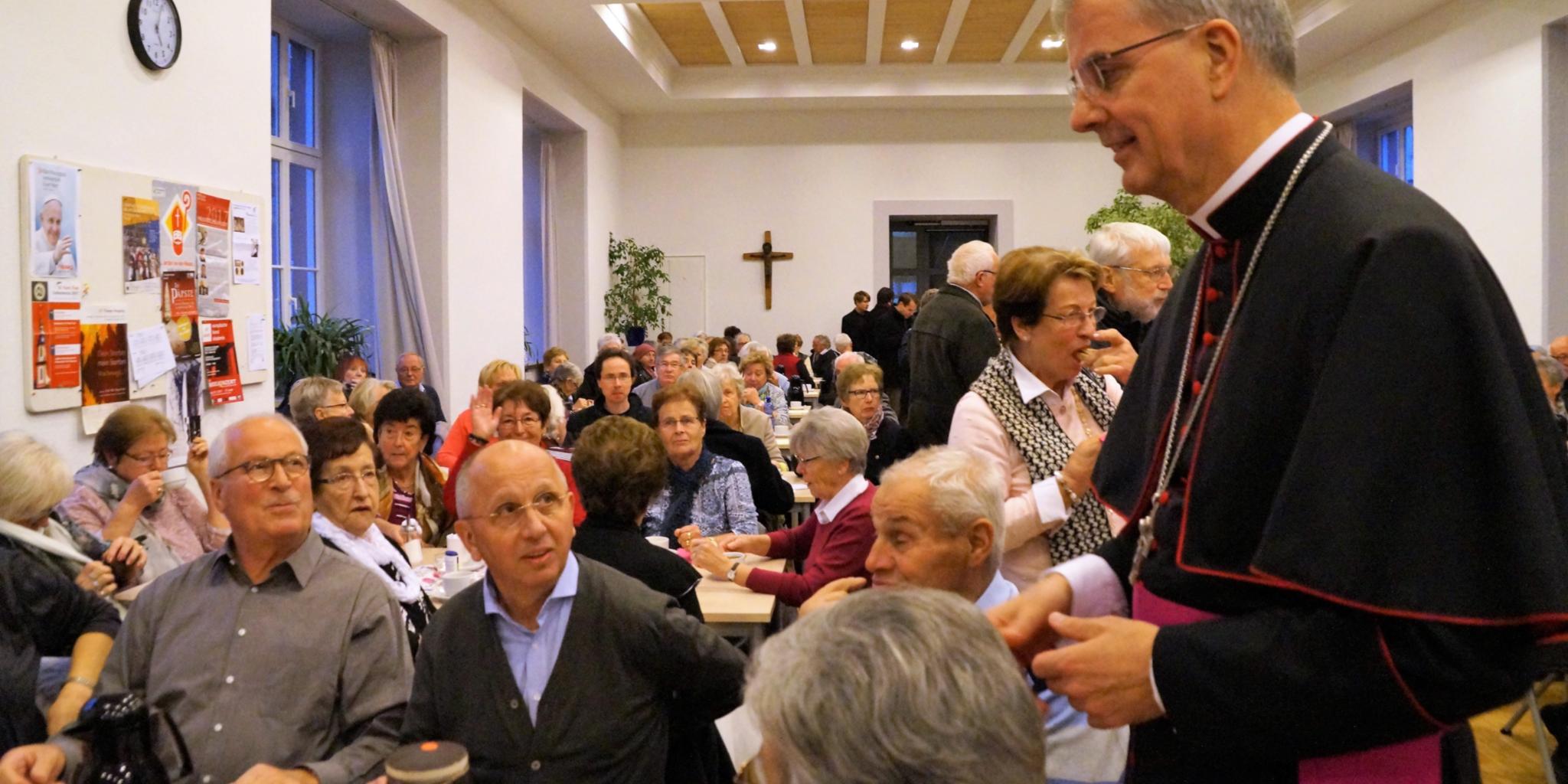 Austausch von Erinnerungen in gemütlicher Runde: Weihbischof Jörg Michael Peters im Gespräch mit Pilgern, die an den Bistums-Wallfahrten nach Lourdes und Fatima teilgenommen haben