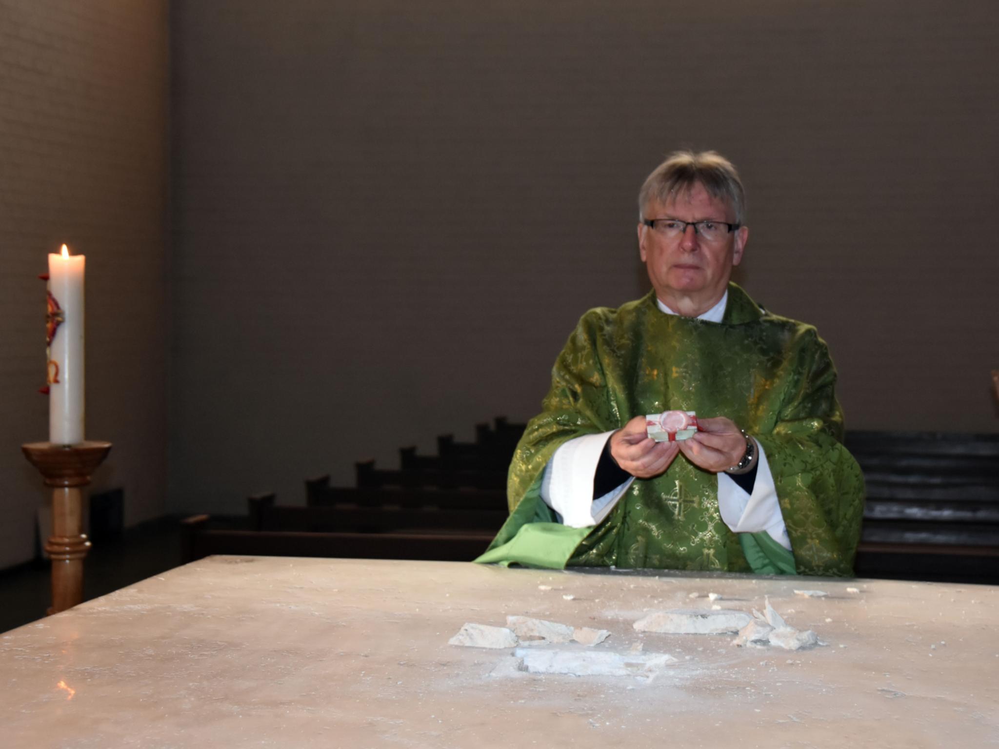 Pastor Klaus Leist entnimmt die Reliquie des heiligen Remigius aus dem aufgebrochenen Altar in Remmesweiler. Foto: Ute Kirch