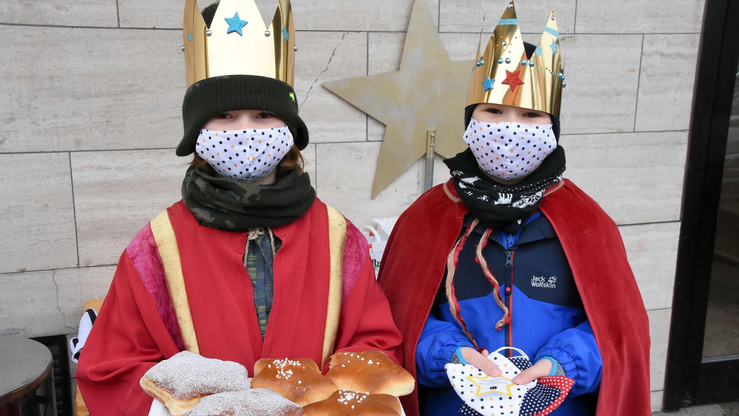 An der Segenshaltestelle an der Bäckerei Krämer: Henri Jung (l) mit Segenssternen aus der Bäckerei und Linus Meyer (r) mit den in jeder Segenstüte enthaltenen Atem-Masken, die eigens für die Aktion hergestellt wurden. Foto: Hans Georg Schneider