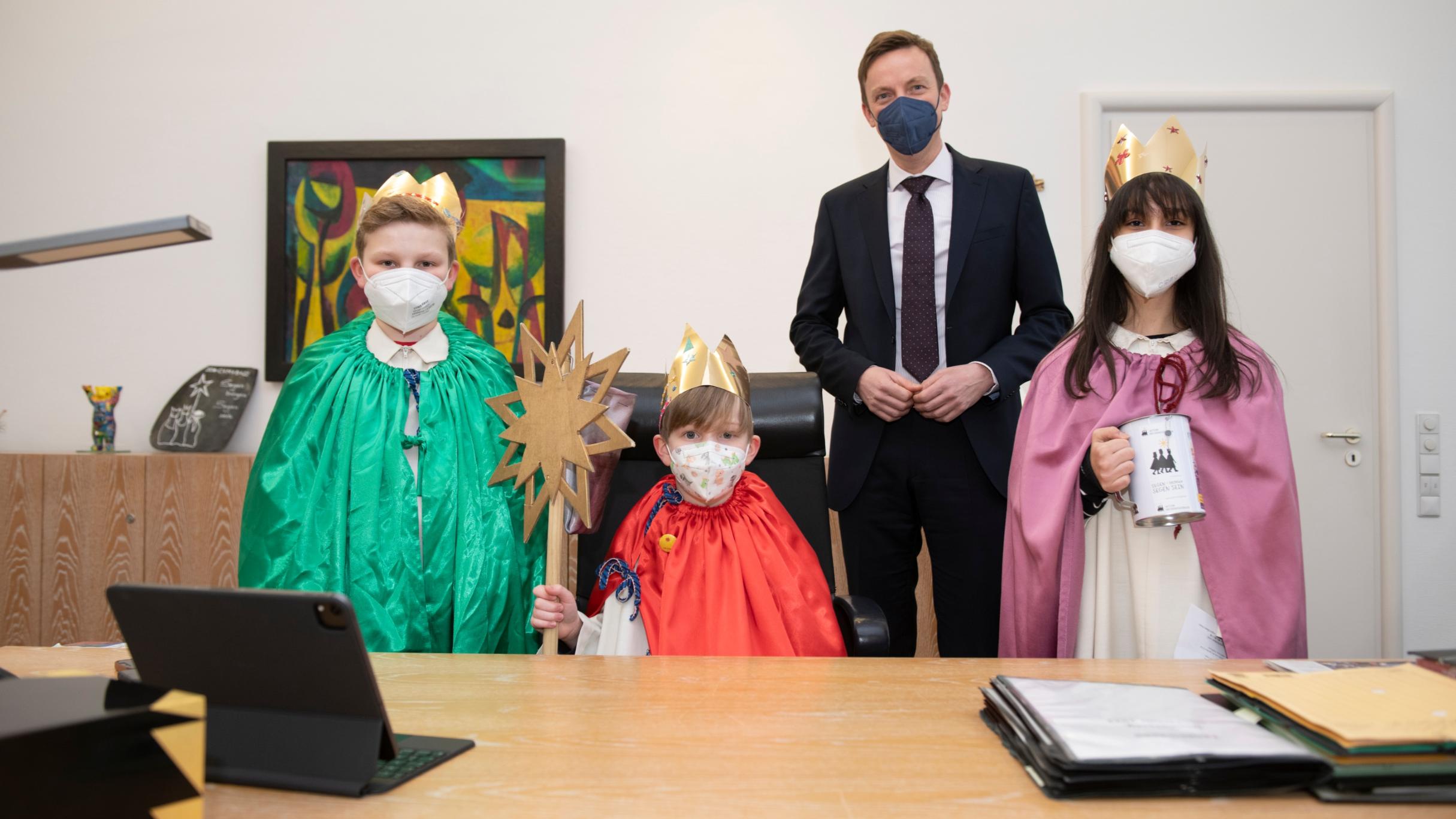 Die Sternsinger Leander, Elian und Maria Virginia mit Ministerpräsident Hans in seinem Büro. Foto: Jennifer Weyland/Staatskanzlei