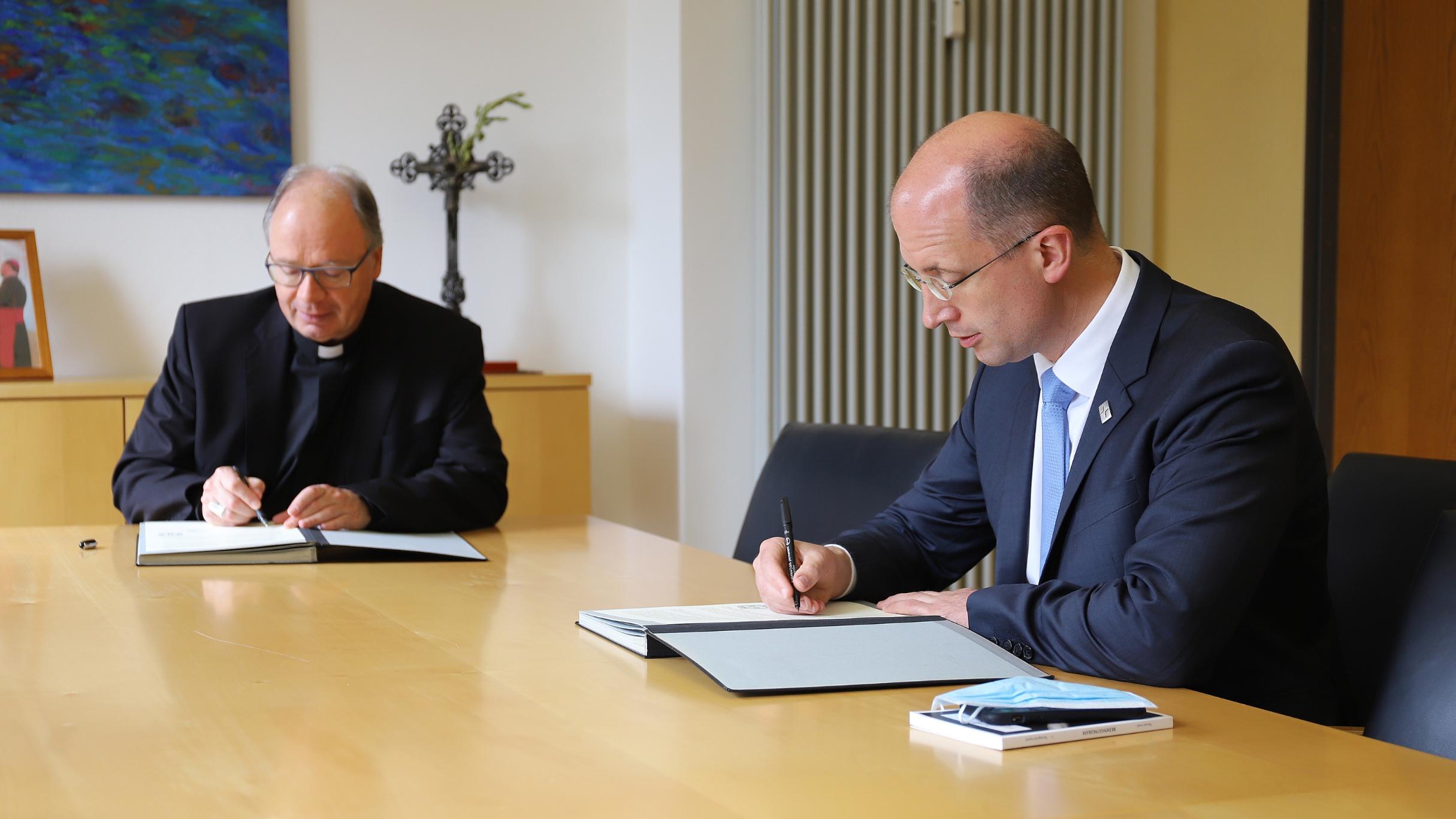 Bischof Ackermann (li.) und Präses Latzel unterzeichnen die Vereinbarung zur konfessionellen Kooperation beim Religionsunterricht (Foto: Bistum Trier/Inge Hülpes)