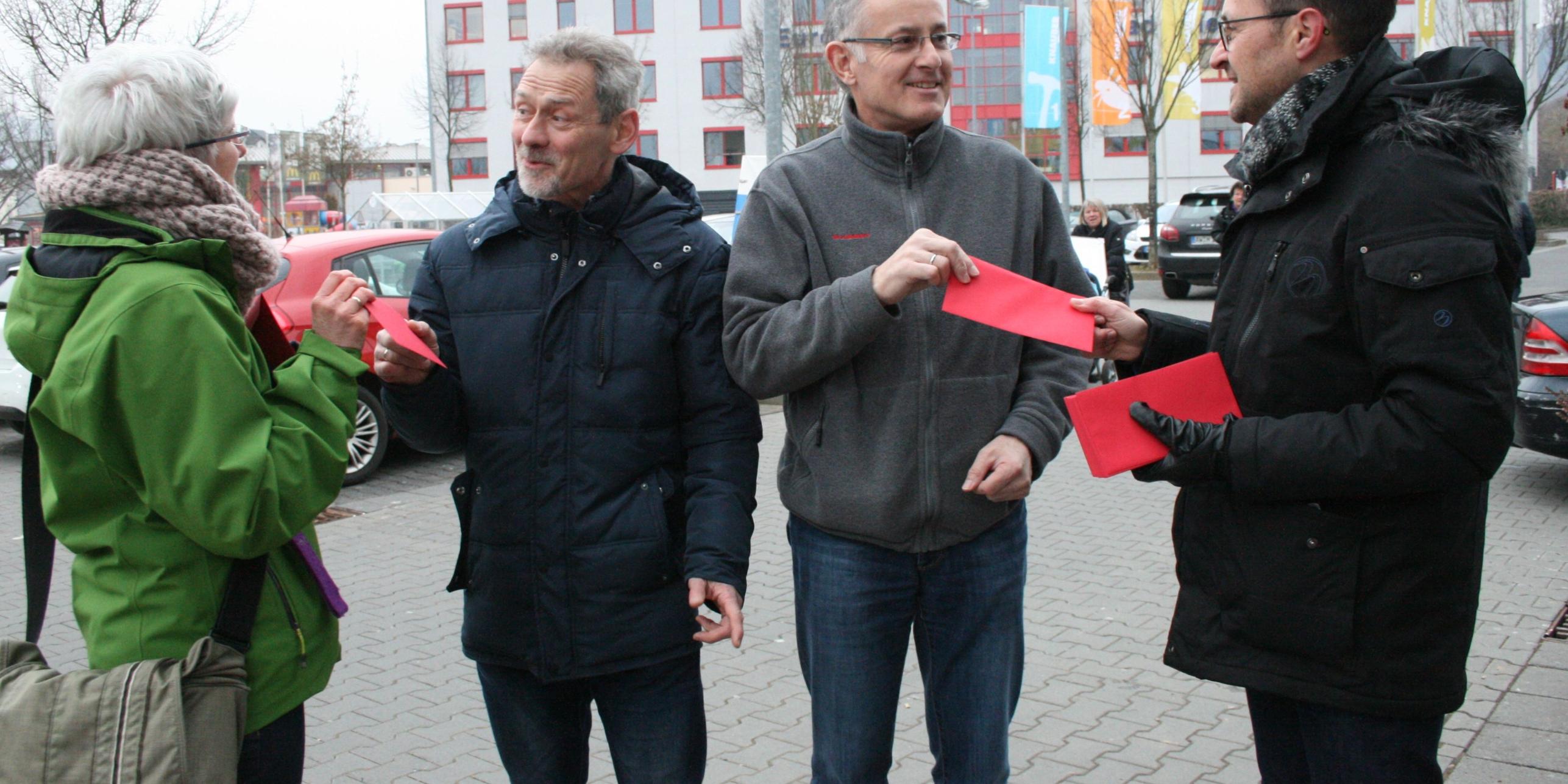 Horst Scheufen (Zweiter v. links) und Stefan Groß (Zweiter v. rechts) freuen sich über die Liebesbriefe von Gott, die ihnen Ute Herhold (links) und Pfarrer Jörg Meyrer (rechts) überreichen.