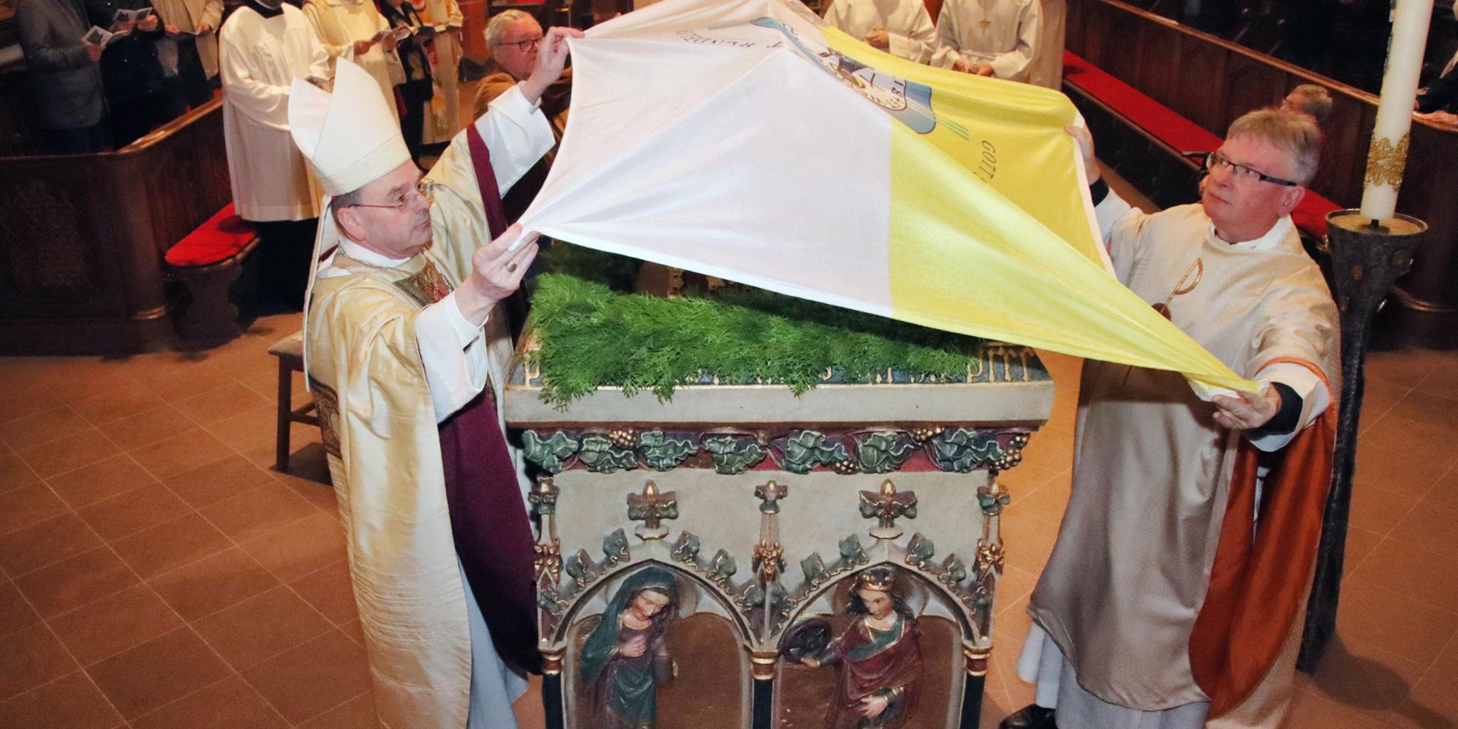 Weihbischof Robert Brahm und Pastor Klaus Leist verhüllen den Schrein des heiligen Wendelin. Foto Josef Bonenberger