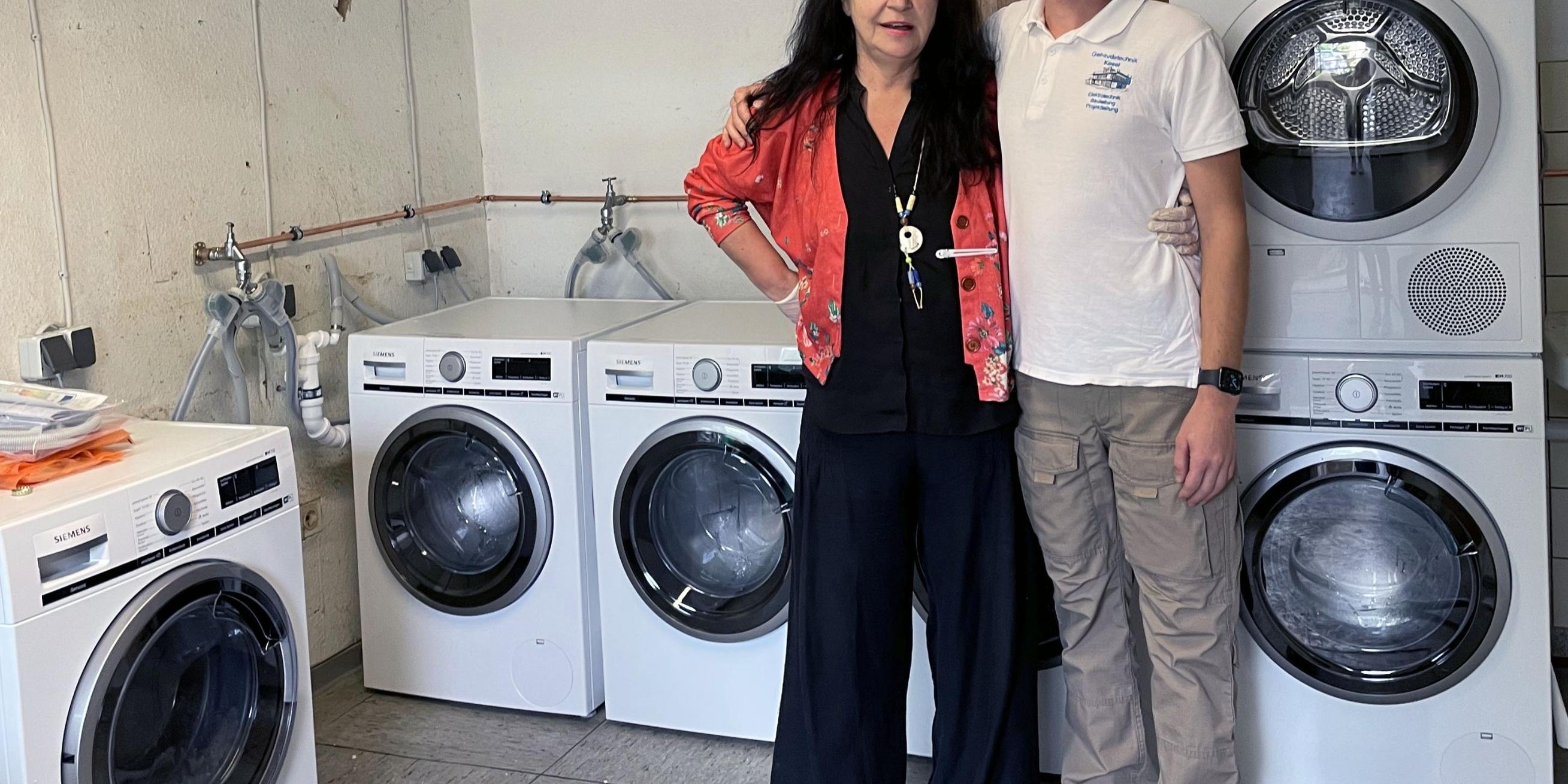 Die Leiterin des HoT, Petra Klein, mit einem Elektrikermeister aus dem brandenburgischen Senzech. Die Waschmaschinen und ihr Anschluss waren eine Spende. Für die Betroffenen aus dem Ahrtal wurde so im HoT ein Waschsalon eingerichtet, wo kostenlos gewaschen werden kann. (Foto: privat)