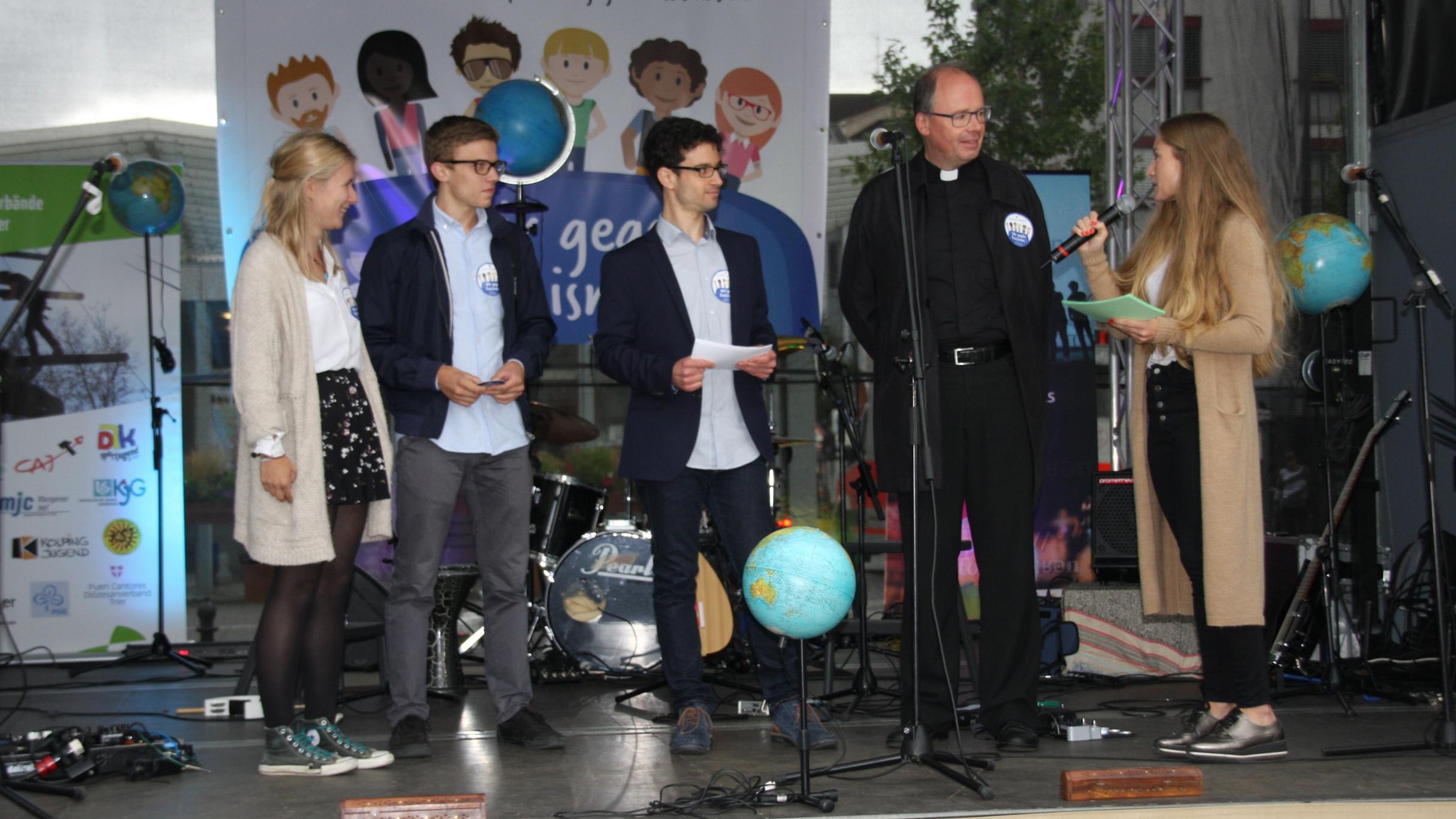 Bischof Ackermann beantwortet die Fragen der Moderatoren Lena Binz (rechts) und Christopher Hoffmann (Dritter v. links). Paulina und Johannes erklären den Ablauf der Aktion.