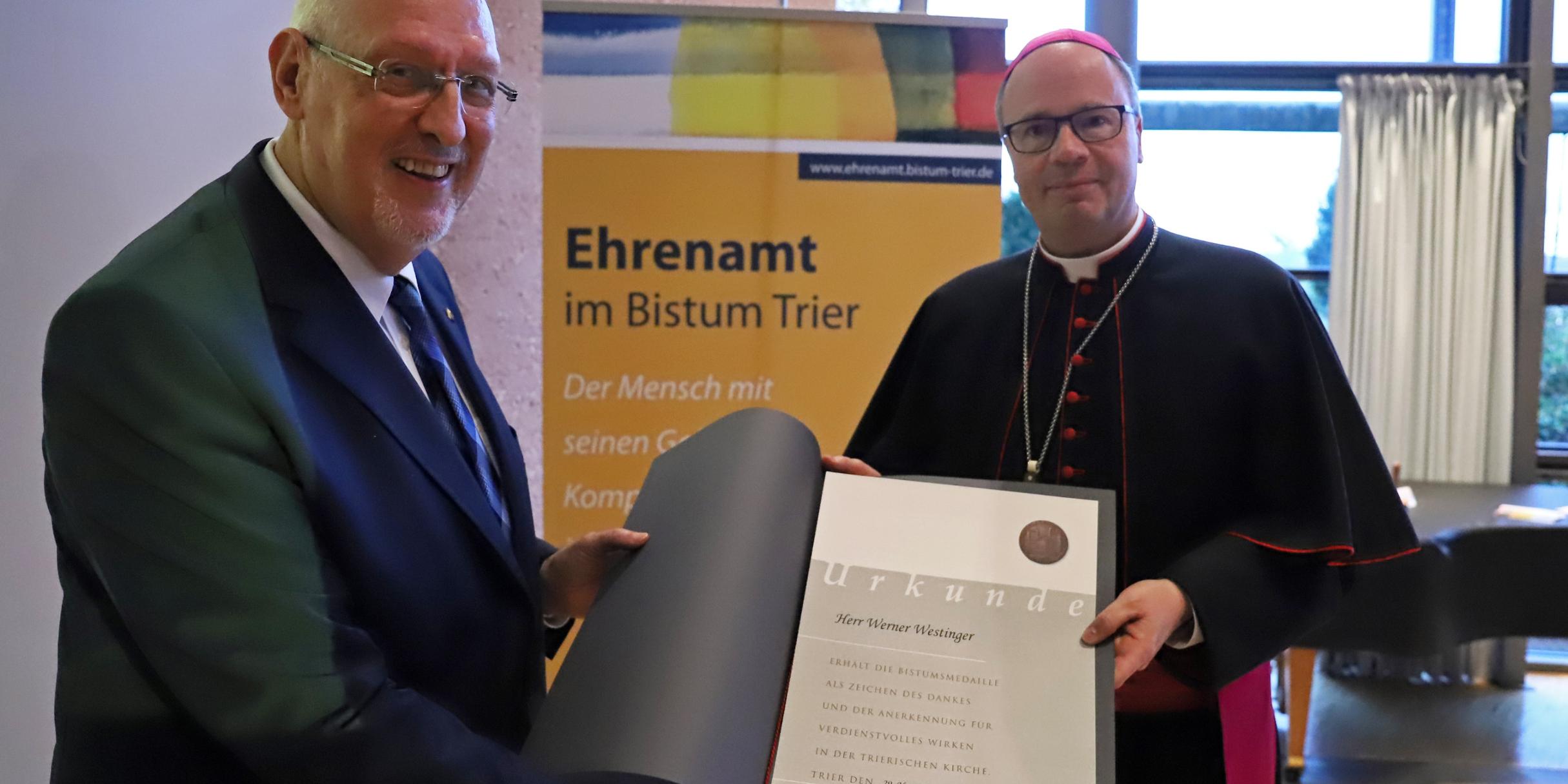 Bischof Ackermann überreicht Werner Westinger (links) aus Weißenthurm die Bistumsmedaille.