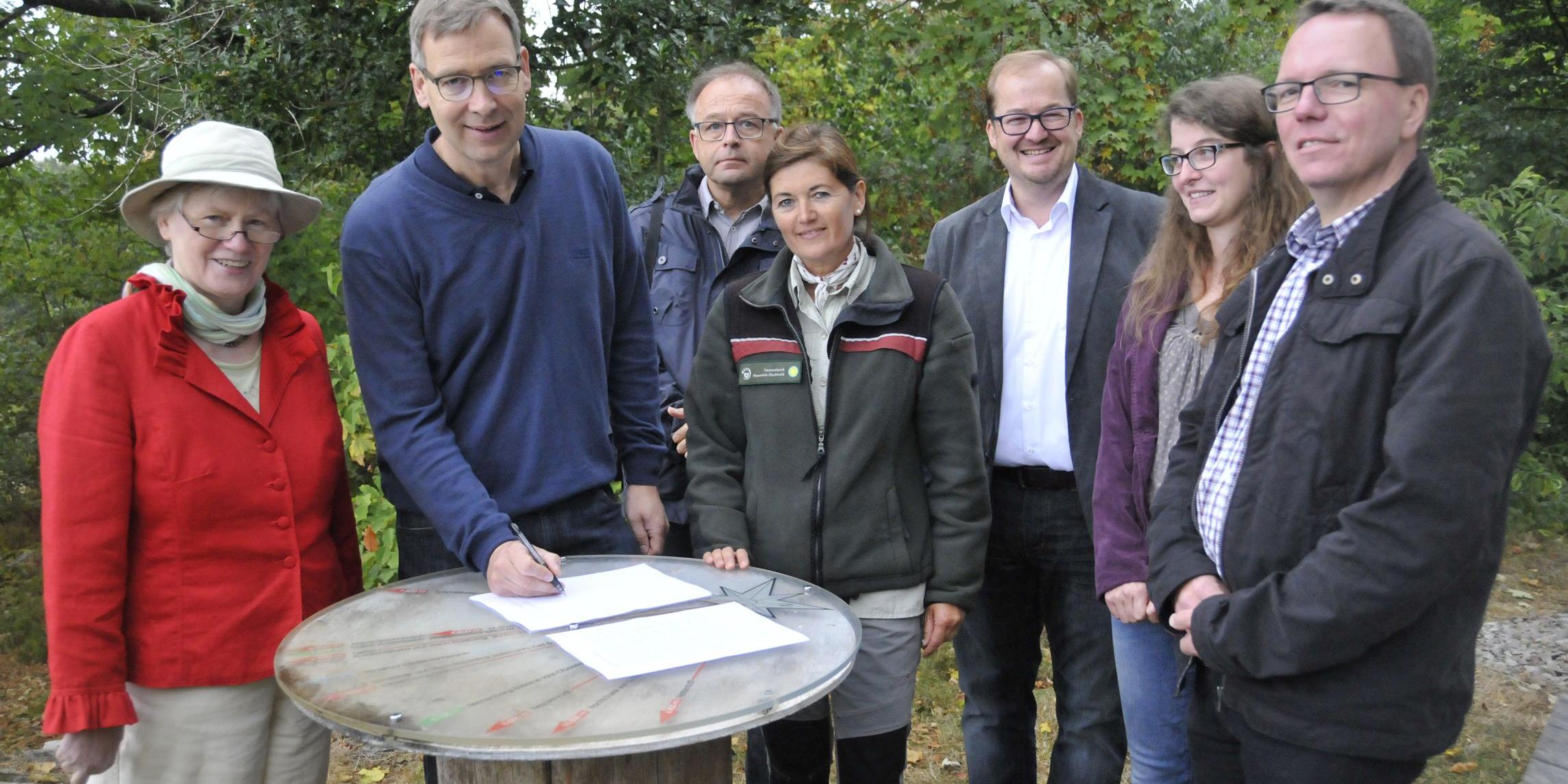 Superintendent Dr. Jörg Weber (2.v.l.), Anne Speicher (Nationalparkamt, 4. v.l.), Dechant Clemens Grünewald (3. v.r.), sowie Pastoralreferent Claus Wettmann (rechts) bei der Unterzeichnung der gemeinsamen Erklärung im Kreis weiterer Unterstützer des Projektes.
