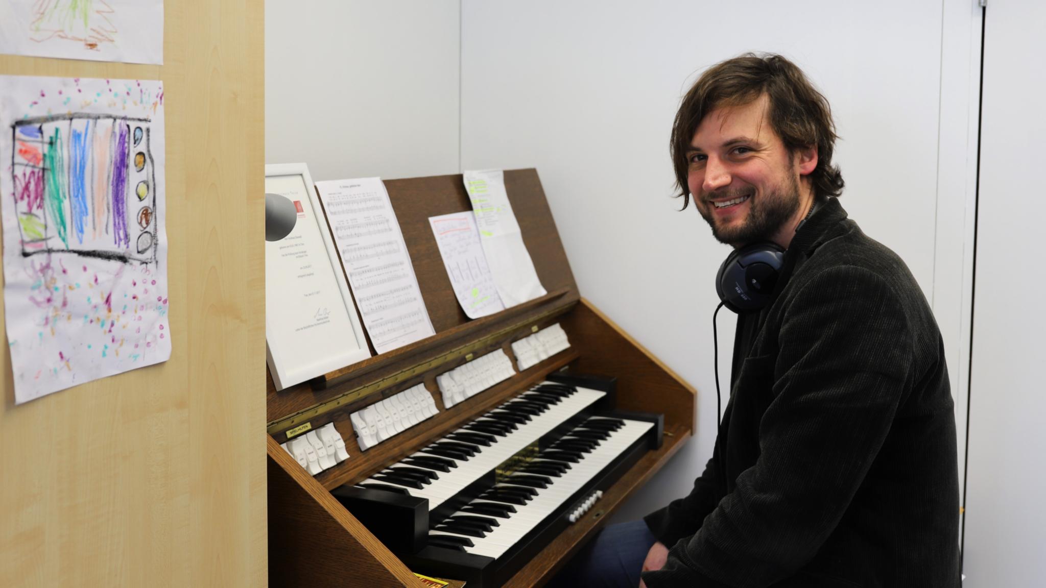 Andreas Diewald an der kleinen Orgel in seinem Büro an der Hochschule Trier.