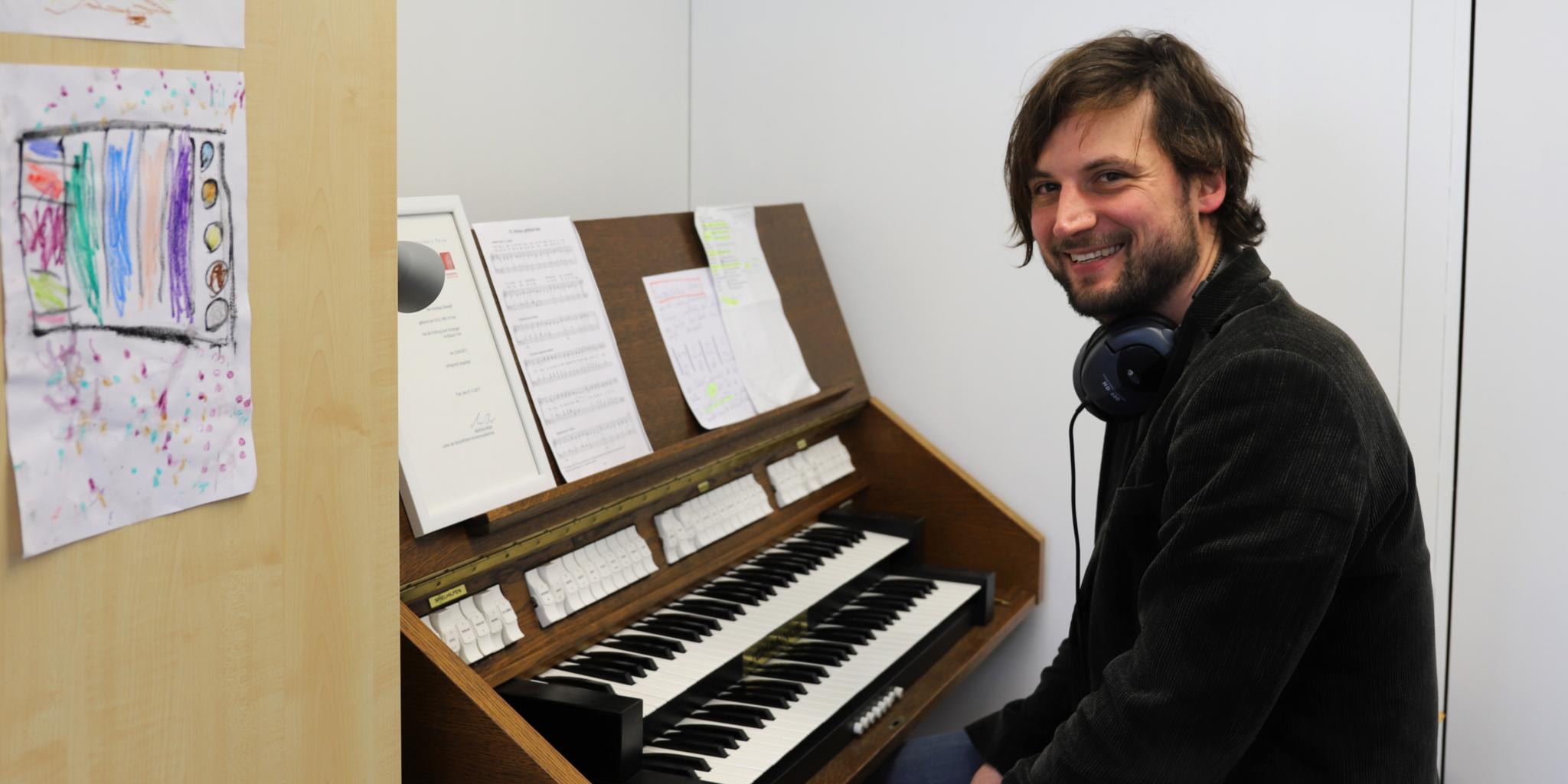 Andreas Diewald an der kleinen Orgel in seinem Büro an der Hochschule Trier.