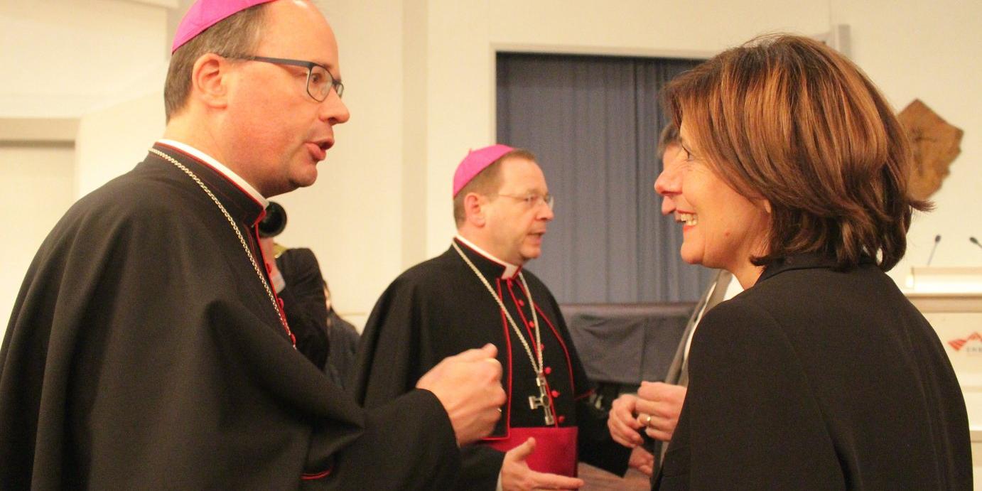 Bischof Stephan Ackermann im Gespräch mit Ministerpräsidentin Malu Dreyer; im Hintergrund steht Bischof Georg Bätzing. © Bistum Mainz / Blum