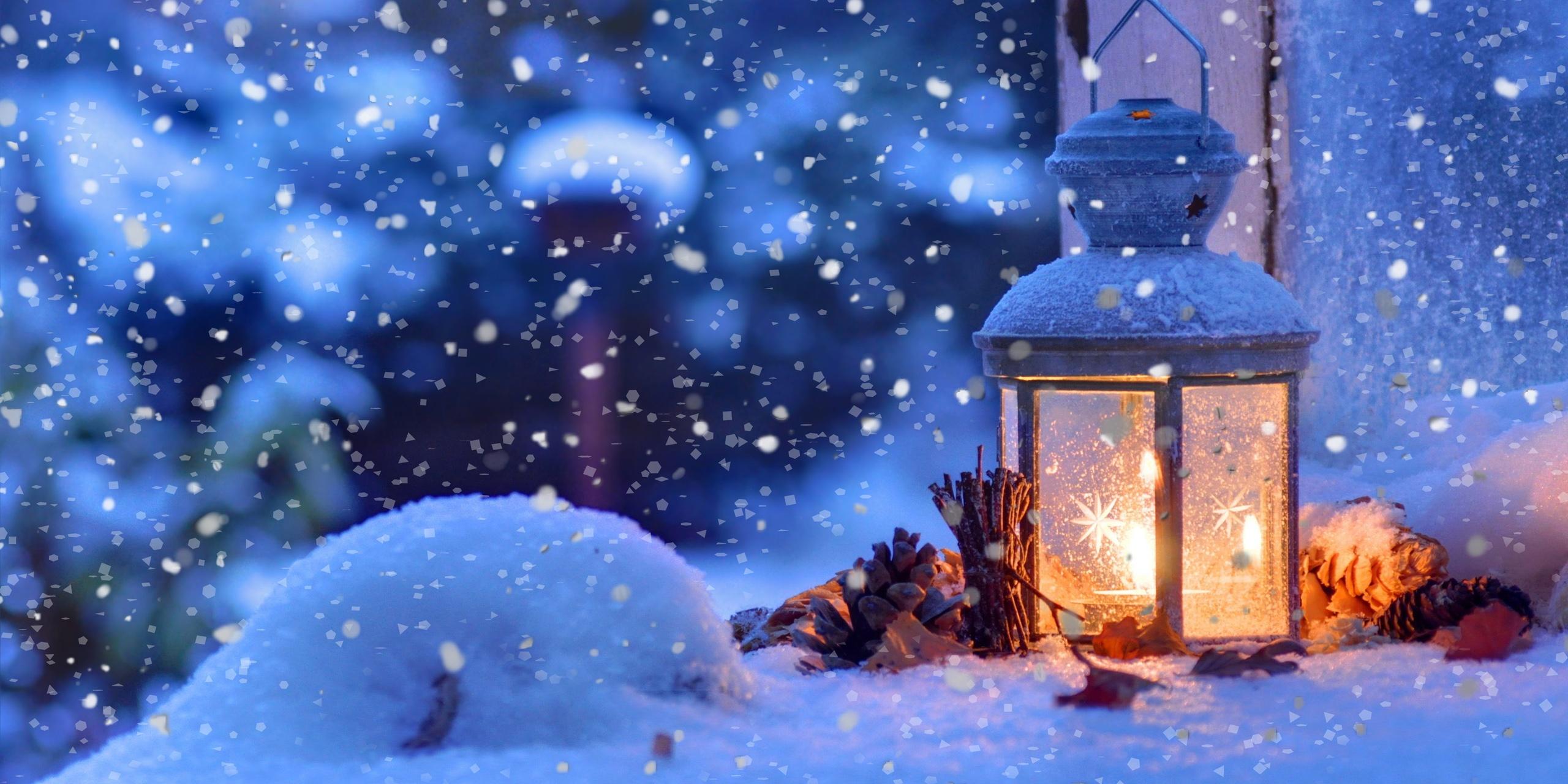 Auf dem Titelbild des diesjährigen Adventskalenders ist eine verschneite Laterne, vor einem Fenster in weihnachtlicher Abendstimmung zu sehen.